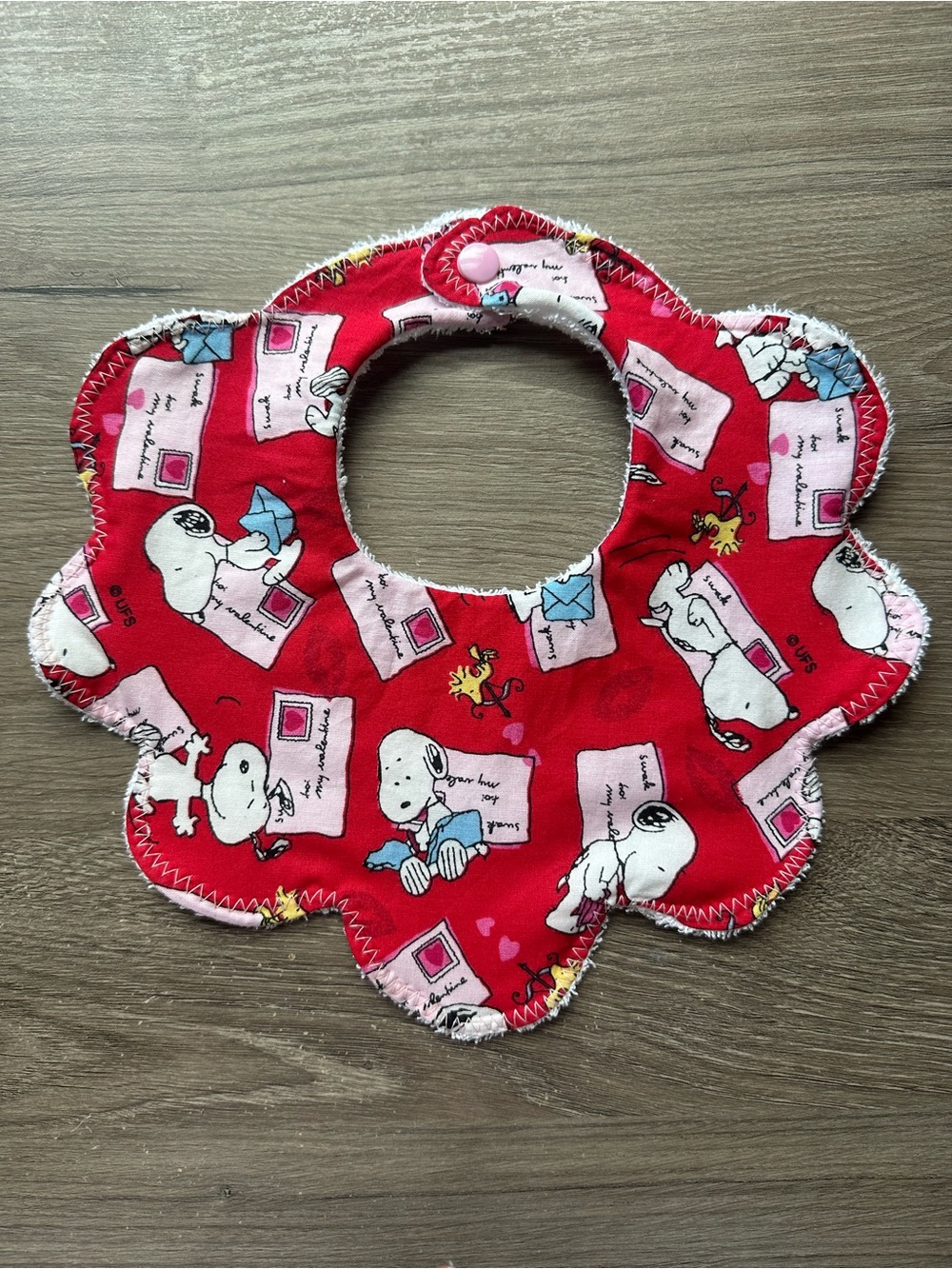 Peanuts Floral-Edged Snoopy Bib in Red and Pink